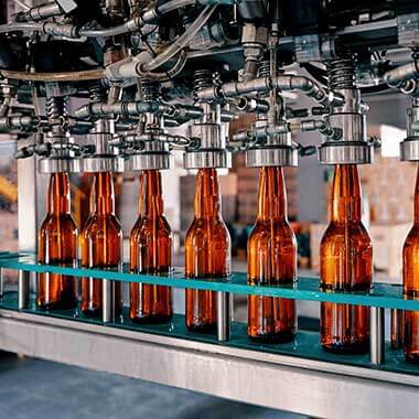 Sticle care se deplasează printr-o fabrică de producere a băuturilor. Monitorizarea durităţii apei este importantă pentru gestionarea calităţii produsului.